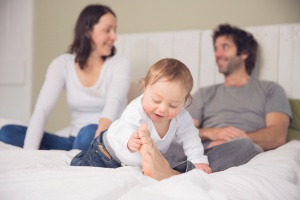 Pendle Lancashire - Baby playing with his dad's foot, mum and dad smiling in the background