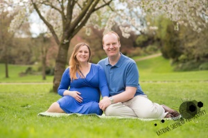 Avenham Miller Parks Preston - Couple sat together in front of a blossom tree, mum has her hand on her baby bump